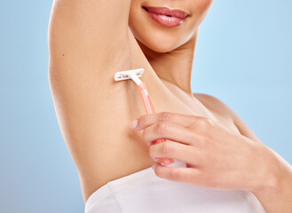 Woman, shaving and beauty or underarm in studio, cleaning and hair removal for hygiene treatment. Female model person, epilation and skincare or armpit, razor and dermatology on blue background