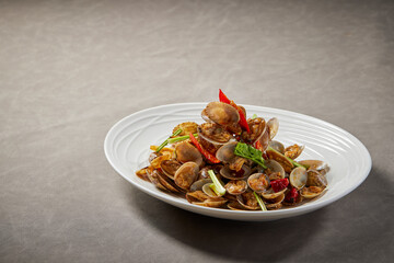 traditional chinese wok fried seafood fresh clam Lala with spicy chilli sauce in plate on grey stone table asian cafe hotel luxury halal food restaurant banquet menu