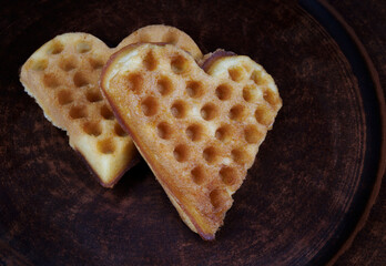 Венские вафли в форме сердца оставляют на глиняной тарелке.