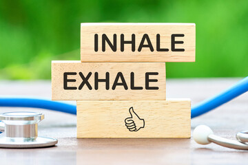 Extensive concept from meditation. Inhale - Exhale written on wooden bars next to the stethoscope