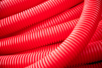  Red plastic tubing for underground cable protection as background .