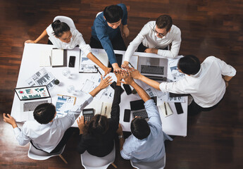 Top view diverse office worker join hand together in office room symbolize business synergy and...