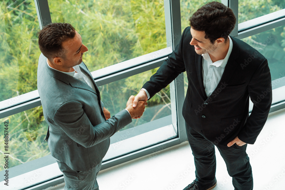 Wall mural businessman handshake with another businessman partner in modern workplace office. people corporate 