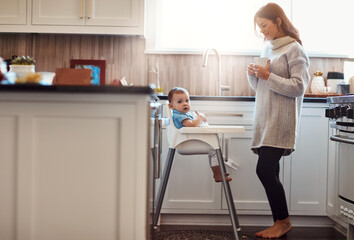 Kitchen, mom and happy with baby in high chair in home with playing and busy with house keeping. Parent, woman and toddler for child development or growth with care, support and trust or bonding