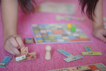 Fototapeta premium 小学生の子供がボードゲーム遊びを楽しんでいる様子。