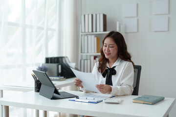 Asian businesswoman, attractive stylish woman working on financial and accounting documents. Laptop on the table in the office startup business idea.