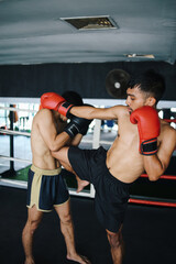 MMA Young Asian Male Fighter Kicking Attack With Knee At Boxing Arena. Muay Thai
