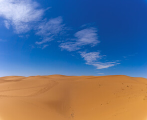 sand dunes in the Sahara Desert of Africa under a blue sky