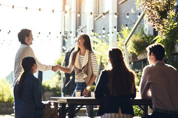 Business people, greeting and handshake in meeting at restaurant for welcome, b2b networking or remote work outdoor. Teamwork, happy and shaking hands for onboarding, partnership deal or agreement