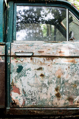 Side view of an old olive-green car.