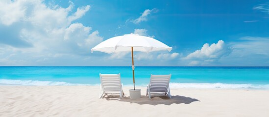 Obraz premium Stunning beach banner showcasing a picturesque beach landscape with white sand beach chairs and an umbrella ideal for travel and tourism with ample copy space image