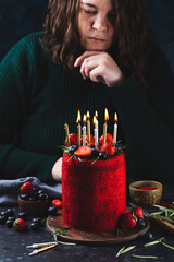 Red velvet cake with candles. Birthday cake decorated with strawberries and blueberries