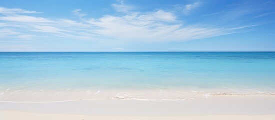 Obraz premium Clear blue sky over a white sandy beach with a serene blue sea creating a copy space image