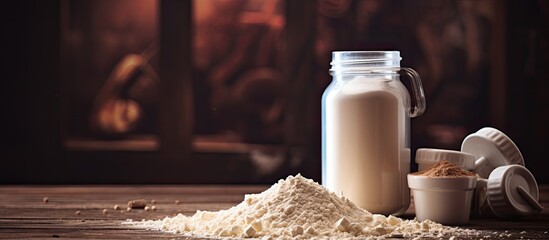 Weight lifting equipment and a container of protein powder are placed on a table creating a fitness themed composition with copy space image