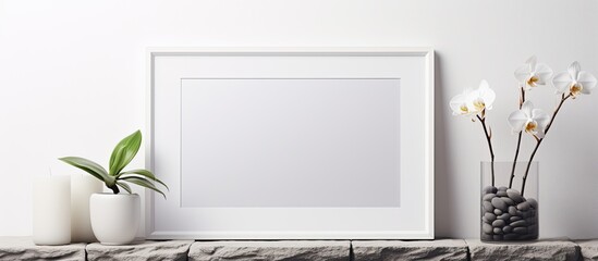 Modern room decor featuring a picture frame mockup a shelf against a white wall holding a decorative candle glassware rocks and a potted orchid plant Includes copy space image