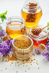 Raw organic bee pollen and honey in jars.
