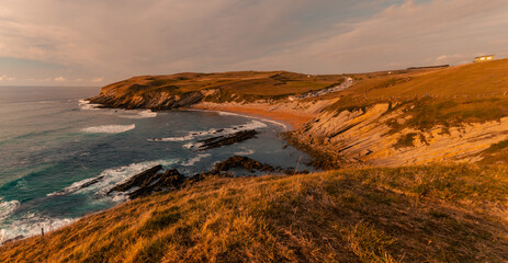 Sunset at the beach, on a summer day. Coast with yellowish meadow at the north of Spain
