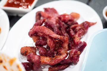 Sun-Dried Pork (Moo dad deaw), on white plate - Asian and Thai food style.