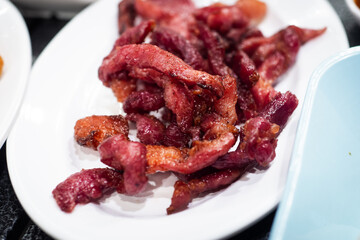 Sun-Dried Pork (Moo dad deaw), on white plate - Asian and Thai food style.