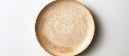 Neutral beige pottery plate on a white studio backdrop in a high angle view for food styling in advertising with copy space image