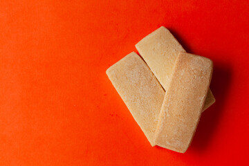 Stacked coconut butter cookies, on an orange background. Top-down view. Food Flat lay.