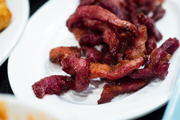 Sun-Dried Pork (Moo dad deaw), on white plate - Asian  and Thai food style.