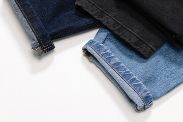 Close-up of rolled jean cuffs in various denim shades, showcasing fabric textures.