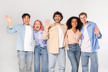 A group of five young adults, representing diverse ethnicities and genders, stand together against a white background. They are all smiling and appear to be happy and friendly.