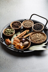 Traditional Garam masala ingredients, whole Indian spices on a gray background vertical