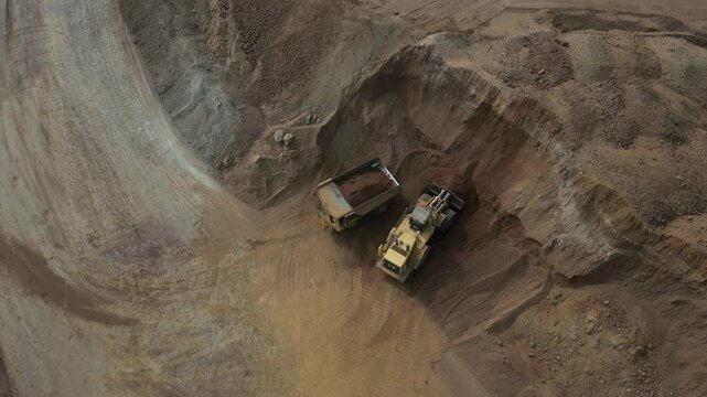 An excavator is filling up a huge truck at a nickel mining site in western australia.