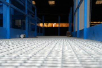 Obraz premium Metallboden einer Industrieanlage mit Licht im Hintergrund gerillter Boden