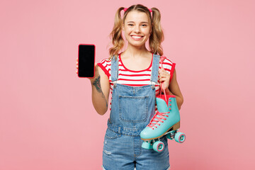 Young woman wear red t-shirt denim overalls casual clothes hold blue rollers use blank screen workspace area mobile cell phone isolated on plain pink background Summer sport lifestyle leisure concept