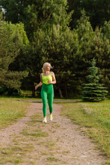 Pretty female athlete running on a track in the park. A woman is jogging