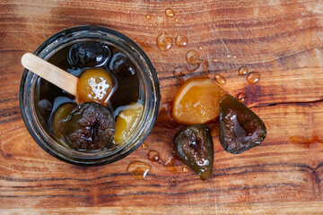 
fig and ginger preserve in jar on rustic wooden board with spoon and copy space
