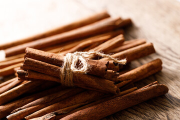 Cinnamon sticks dried tree bark spice on rustic wooden table background. Selective focus.