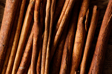 Cinnamon sticks dried tree bark spice on rustic wooden table background. Selective focus.