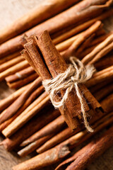 Cinnamon sticks dried tree bark spice on rustic wooden table background. Selective focus.