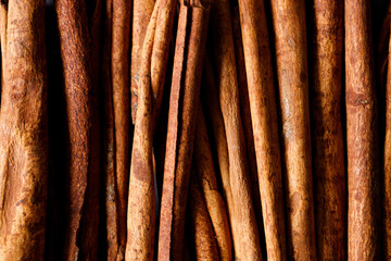 Cinnamon sticks dried tree bark spice on black stone table background. Selective focus.