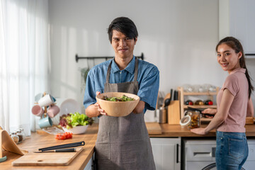 Asian young male amputee without arm cooking foods in kitchen at home. 