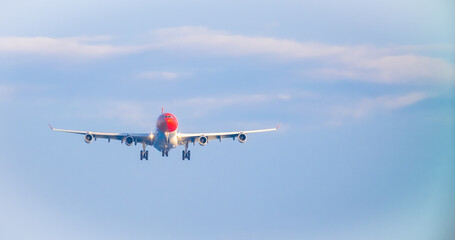 The plane lands over the sea at Phuket airport. A passenger plane lands on Mai Khao Beach, a popular tourist attraction.