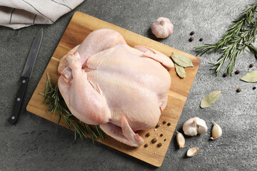 Fresh raw chicken with spices and knife on grey textured table, flat lay