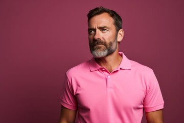 Obraz premium Portrait of a content man in his 40s wearing a breathable golf polo in solid color backdrop