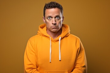 Fototapeta premium Portrait of a glad man in his 40s wearing a zip-up fleece hoodie isolated on solid color backdrop