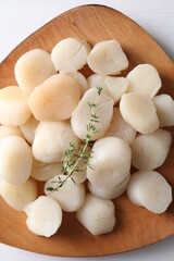 Fresh raw scallops and thyme on white wooden table, top view