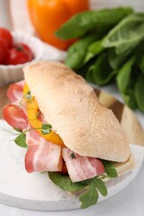 Tasty sandwich with bacon and bell pepper on white table, closeup