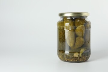 Pickled cucumbers in jar on light background. Space for text