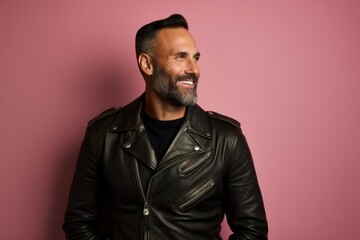 Obraz premium Portrait of a satisfied man in his 40s sporting a classic leather jacket over solid pastel color wall