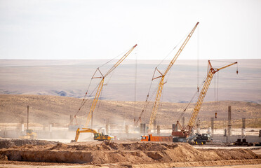 Lifting cranes and other equipment at a construction site. A group of lifting platforms for...