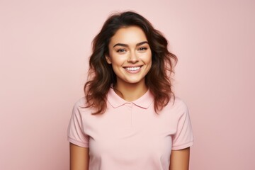 Fototapeta premium Portrait of a happy woman in her 20s wearing a sporty polo shirt on solid pastel color wall