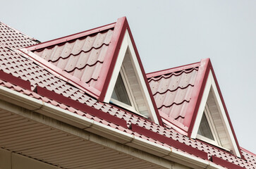 Roof of a building with metal tiles against the sky